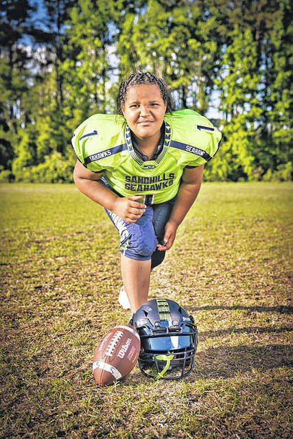 Pads to pom-poms: Young lady splits time between cheering for and playing  football